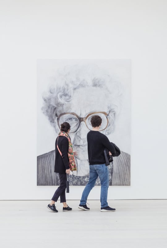 people standing in front of a painting