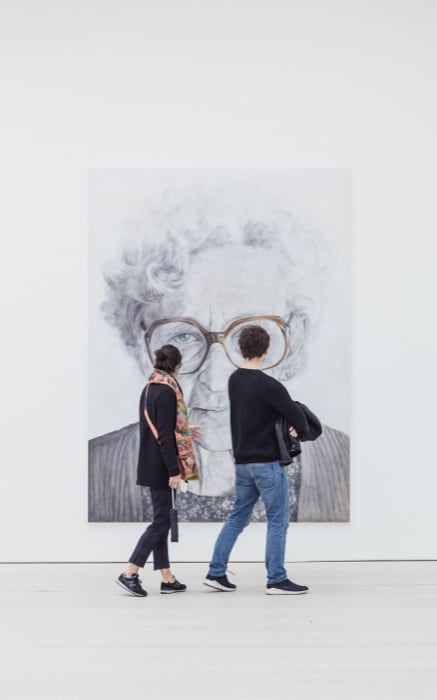 people standing in front of a painting